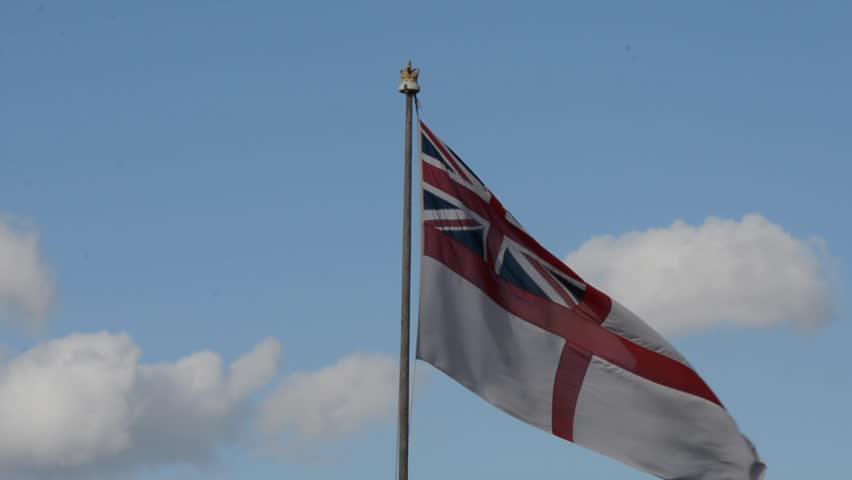 The Queen's Walk, London , UK 10 April 2023 : White Ensign which is Royal Navy flag of the UK , flowing in HMS Belfast