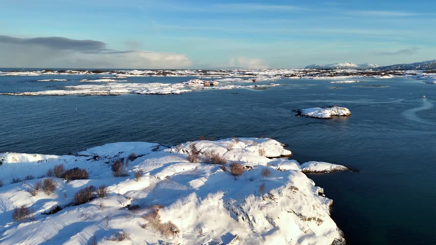 A drone view of snow-covered Haaholmen, Nestled among countless islands near the Atlantic Ocean Road in Averoy, Norway