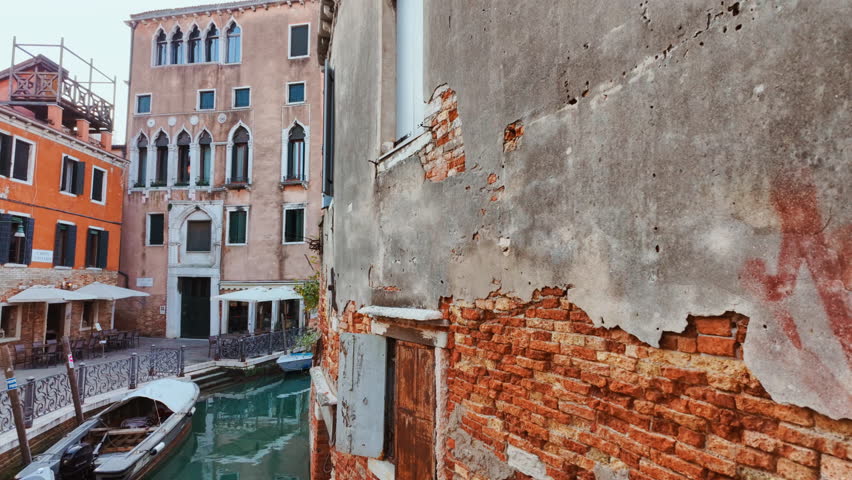 Stunning view of one of the famous canals in Venice, Italy along with quirky buildings, powerful reflections and vivid green water. Venice is an archipelago of 126 islands linked by 472 bridges
