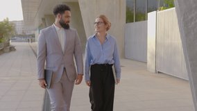 A professional African American businessman and a thriving businesswoman engage in a meaningful conversation outdoors, showcasing a collaborative and innovative work environment that fosters teamwork - Powered by Shutterstock - Get 15% off with code: PIKWIZARD15