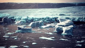 Icebergs and ice floes float serenely in the sea near Iceland, creating a breathtaking, frozen landscape against the backdrop of rugged mountains.
 - Powered by Shutterstock - Get 15% off with code: PIKWIZARD15