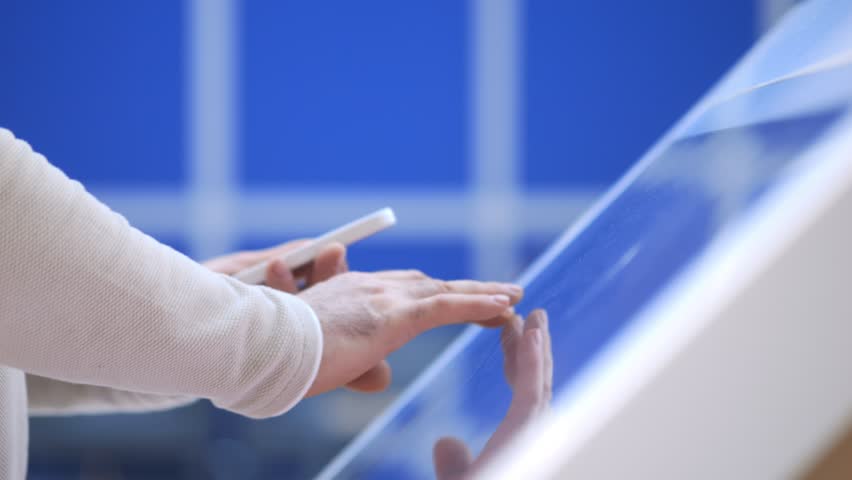 Person is using a cell phone and touching a screen. Concept of technology and the way it has become an integral part of our daily lives. Scene is somewhat serious