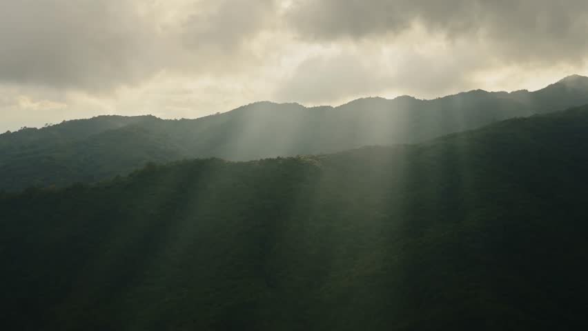 Sun Rays and Dark Mountains Sunset Over a Ridge, Crepuscular Rays aka God Rays with Dramatic Clouds and Sky in Moody Atmospheric Dark Close Up Landscape Scene in the Himalayas in Nepal