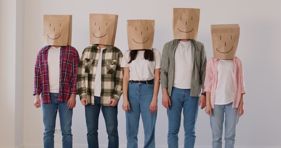 People with paper bags on their heads, each decorated with happy face, give enthusiastic thumbs up. Group of anonymous people stand in row and give positive feedback about customer satisfaction.