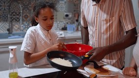 Caucasian mother and African American father teach children to cook pancakes at cosy kitchen at home. Multiethnic family tradition weekend leisure - Powered by Shutterstock - Get 15% off with code: PIKWIZARD15