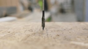 A high-speed close-up captures the moment a drill bit pierces a plywood surface, sending wood particles and sawdust flying in all directions with dynamic force - Powered by Shutterstock - Get 15% off with code: PIKWIZARD15