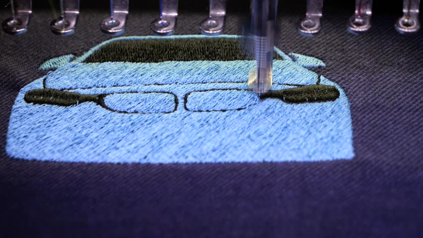 Machine embroidery of a sports car with blue and black thread on a t-shirt. Embroidery of clothes for a gift. Car embroidery design. 4k 5fps video close-up.