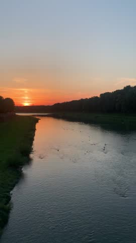 Small river with ducks. Sunset on the river