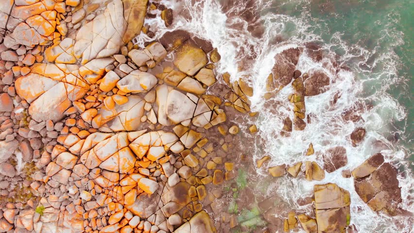 The iconic lichen covered rocks and turqoise ocean water in the Bay of Fires taken as an aerial image near The Gardens in Tasmania, Australia