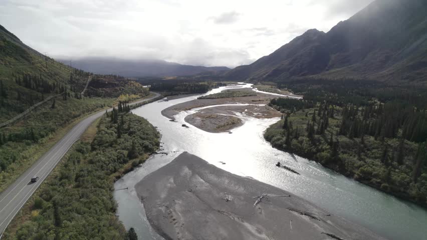 Beautiful river in Alaska with country road and woodland, aerial view