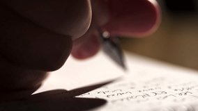 A close up shot of a person hand writing something in English with a pen in longhand. The video has beautiful studio lighting and great visual aesthetic quality. - Powered by Shutterstock - Get 15% off with code: PIKWIZARD15