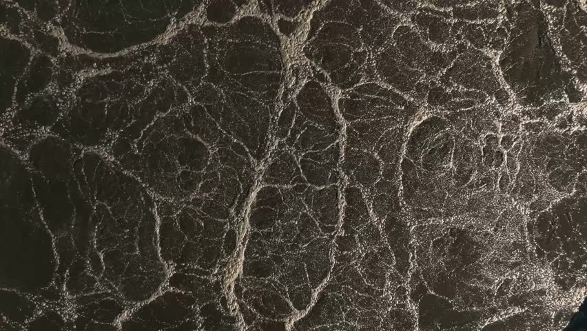 Aerial view of wastewater treatment plant, dark purification tank symbolizing clean water efforts.