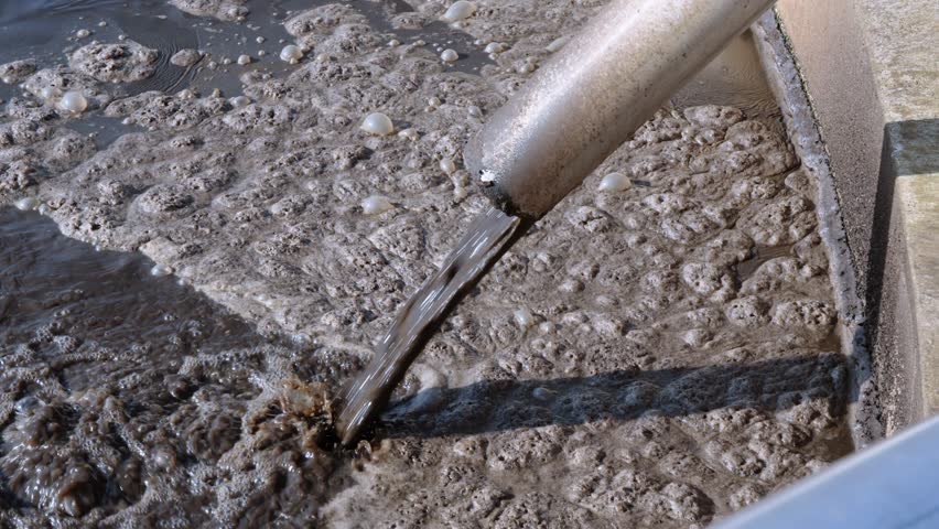 Close-up of wastewater sludge processing, environmental cleanup, brown residue.
