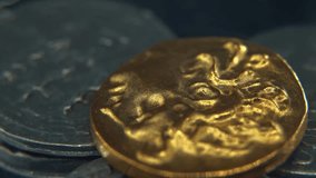 Hyper Macro Gold coin on a pile of Silver metal ancient coins, old drawings historical symbols, on a rotating stand, 4K smooth video - Powered by Shutterstock - Get 15% off with code: PIKWIZARD15