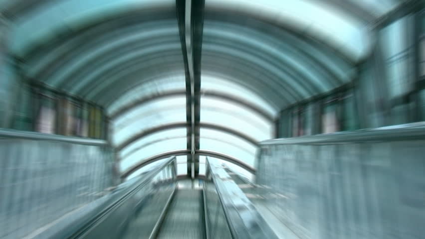 steps of a moving escalator under the glass roof. Zoom Blur