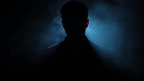 Close-up cinematic HD shot of a mysterious man sitting on a chair with intense rim lighting, creating a dramatic silhouette – perfect for crime, thriller, noir, or stylish character-driven visual stor - Powered by Shutterstock - Get 15% off with code: PIKWIZARD15