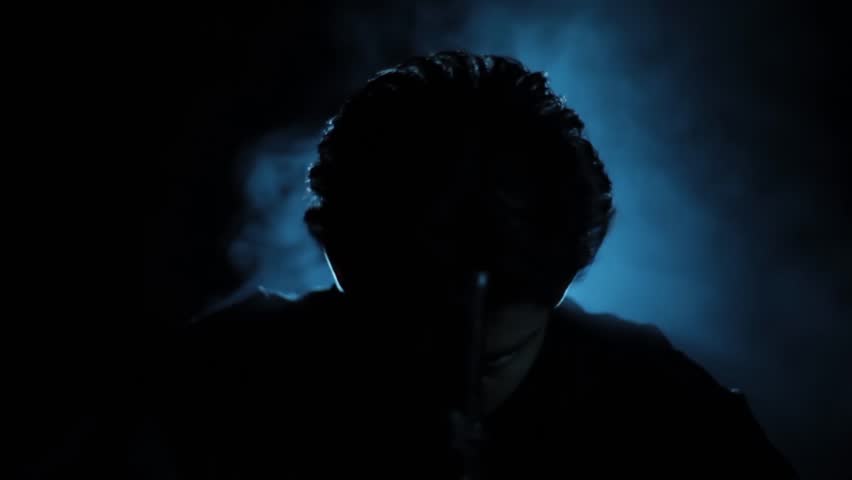 Cinematic HD shot of a powerful gangster sitting confidently on a chair, holding a gun, and commanding his subordinate under moody lighting – ideal for crime, mafia, thriller, or period drama visuals
