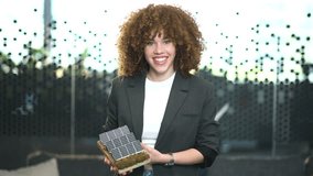 Confident businesswoman holding small scale model house with rooftop solar panels, promoting sustainable architecture - Powered by Shutterstock - Get 15% off with code: PIKWIZARD15