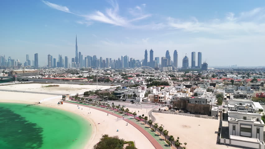 Dubai, United Arab Emirates: Aerial view of modern city skyline taken from Jumeirah, beach and financial district with skyscrapers on horizon - landscape panorama of Arabian Peninsula from above
