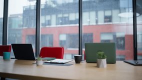 Empty coworking office space with laptops papers coffee cups. Modern corporate workplace with panoramic window on urban view. Contemporary conference room interior with computers. Workspace concept.  - Powered by Shutterstock - Get 15% off with code: PIKWIZARD15