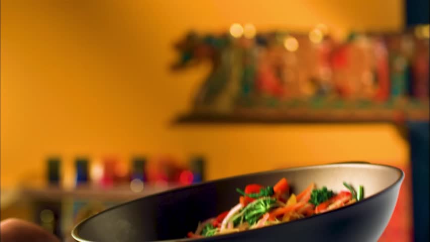 Freeze motion of flying asian wok noodles with prans and vegetable. The concept of meat preparation.