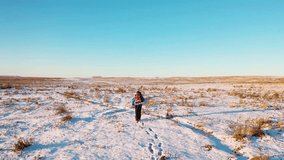 Aerial view of a lonely human walking through snowy desert. Extreme tourism and the concept of survival in extreme cold conditions. FHD footage. - Powered by Shutterstock - Get 15% off with code: PIKWIZARD15