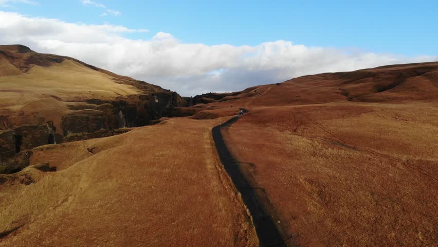 A Serene and Scenic Pathway Meandering Through Beautiful Golden Grasslands Under Vast Blue Skies