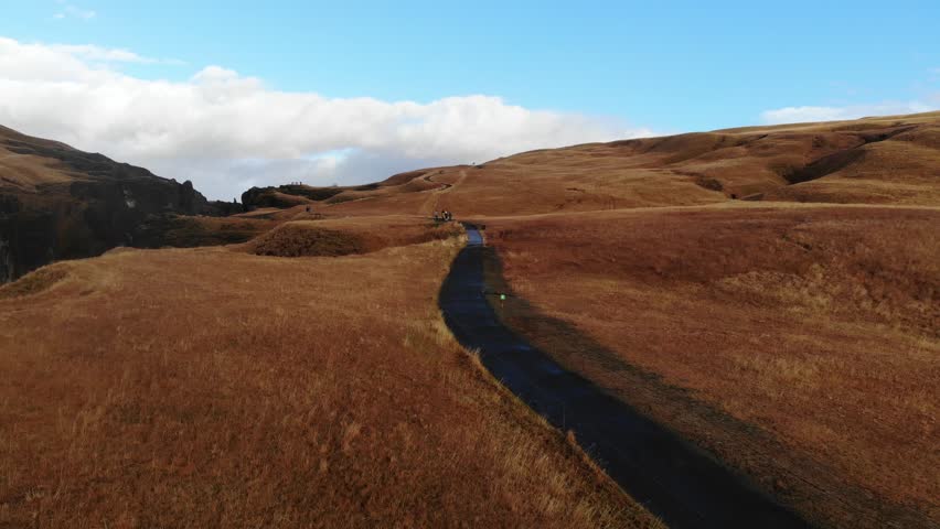 A Serene and Scenic Pathway Meandering Through Beautiful Golden Grasslands Under Vast Blue Skies
