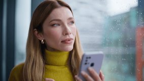 Woman shopping online by cellphone standing by apartment window closeup. Relaxed lady ordering purchases in internet mobile application. Beautiful businesswoman reading work email on smartphone indoor - Powered by Shutterstock - Get 15% off with code: PIKWIZARD15