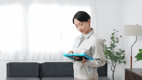A female worker inspecting a room while looking at a tablet - Powered by Shutterstock - Get 15% off with code: PIKWIZARD15