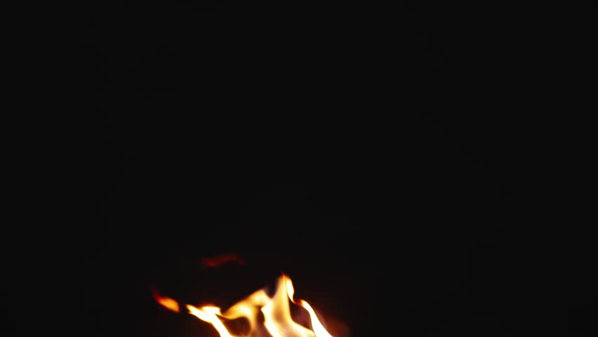 Night campfire flame and sparks in complete darkness. Slow motion. Burning logs, hearth, sparks from fire. Flames of fire and sparks. Joyful peaceful cinematic wilderness. Video for background