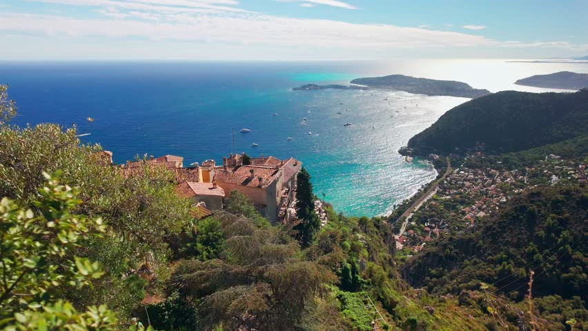 Scenic view of the Mediterranean coastline, medieval houses and exotic garden from the top of the medieval village of Eze on the French Riviera. Revealing steadicam footage