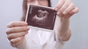 Female obstetrician-gynecologist professionally and thoughtfully helps patients plan pregnancy using ultrasound images. - Powered by Shutterstock - Get 15% off with code: PIKWIZARD15