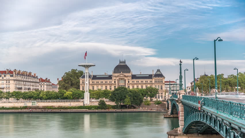 Panoramic hyperlapse view of the Rhone River and its embankment, featuring the University Jean-Moulin in Lyon, France. Includes the University Bridge and waterfront under a partly cloudy sky timelapse
