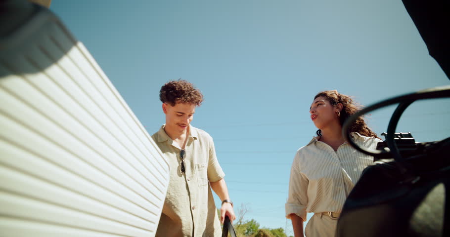 Couple, luggage and trunk of car for travel, holiday or vacation preparation outdoor. Man, woman or loading suitcase in vehicle, transport or truck bed for road trip adventure or journey in low angle