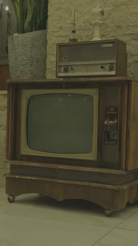Vintage television set, retro TV with wood frame, old radio on top, analog electronics, classic home decor, antique screen, nostalgic media device, retro style furniture, old technology object