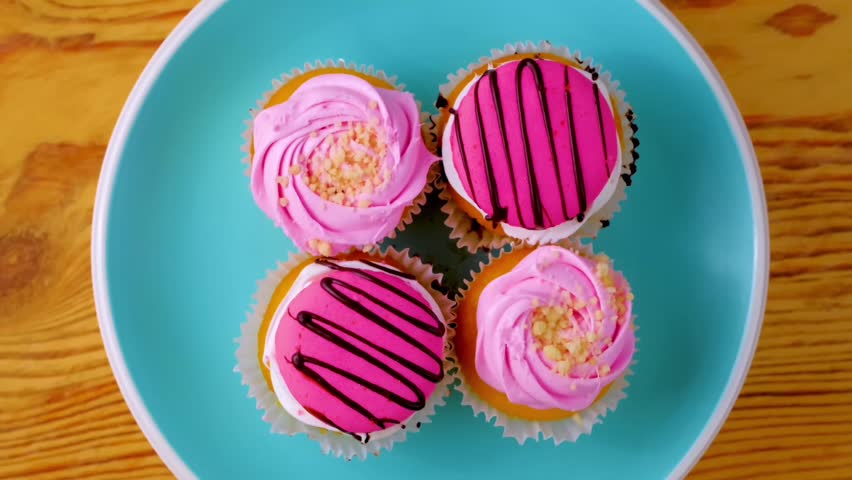 Pink cupcakes with chocolate. Lots of cupcakes for the holiday. Holiday cupcakes with cream and strawberries