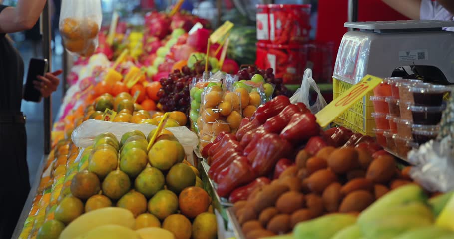 Colorful fruit stand at Thai market with diverse tropical fruits, vegetables, and local produce. Ideal for healthy eating, shopping, commerce, vibrant display, freshness.
