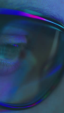 Close-up of tired man working at night on laptop, boy in eye glasses with reflections overworking busy, using computer in dark office