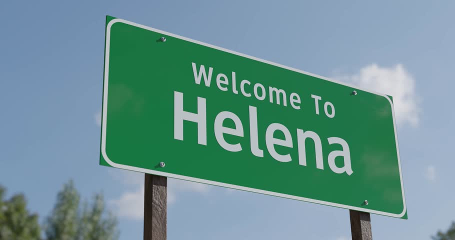 Driving By A Welcome To Helena, Montana Green Road Sign Against a Blue Sky and Clouds - United States Capital Series.
