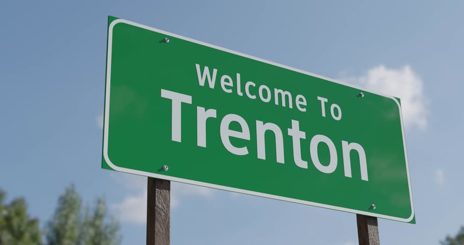 Driving By A Welcome To Trenton, New Jersey Green Road Sign Against a Blue Sky and Clouds - United States Capital Series.