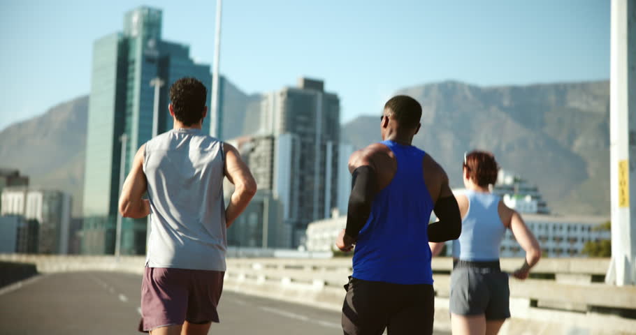 Fitness, exercise and group with running on bridge for marathon training, cardio challenge and performance pace. People, runner club and back in road for wellness competition, jog team and workout