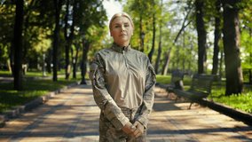 Confident military woman folds arms and looks at camera, standing in park - Powered by Shutterstock - Get 15% off with code: PIKWIZARD15