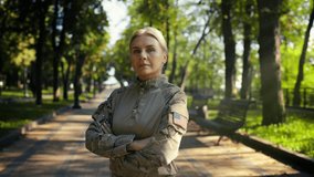 Proud US military woman folds arms, looking at camera in city park setting - Powered by Shutterstock - Get 15% off with code: PIKWIZARD15