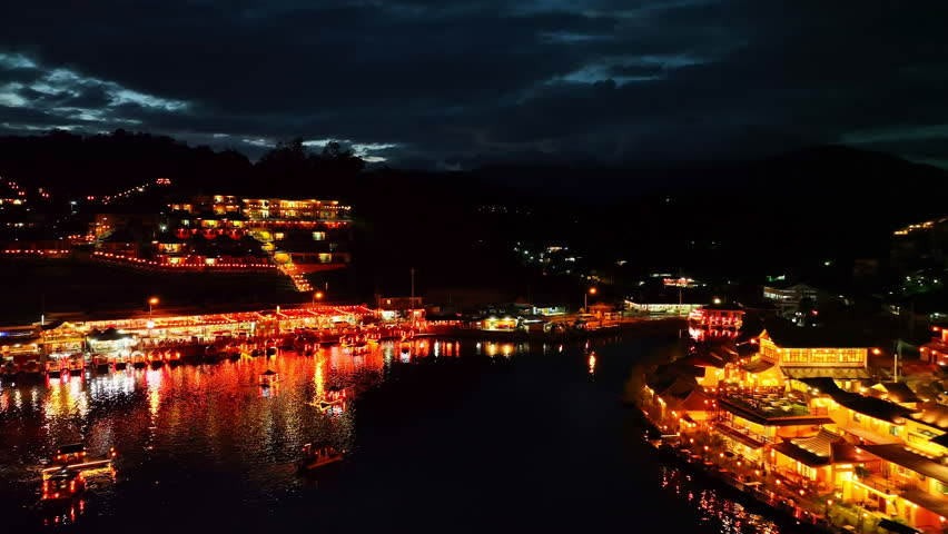 At dusk the reflections of the lights from the village the lake in Chinese-style structures with colorful lights lined the waterfront. Ban Rak Thai is a popular tourist attraction in Mae Hong Son
