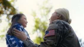 US soldier mother wraps daughter in flag, sharing love and pride for country - Powered by Shutterstock - Get 15% off with code: PIKWIZARD15