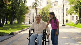 Caring daughter walks beside mom in wheelchair, enjoying peaceful park rest - Powered by Shutterstock - Get 15% off with code: PIKWIZARD15