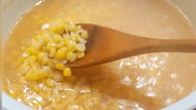 The woman stirs the mashed peas with a wooden spoon.Steam rises in the pan, and when stirring, you can see the boiled peas. - Powered by Shutterstock - Get 15% off with code: PIKWIZARD15