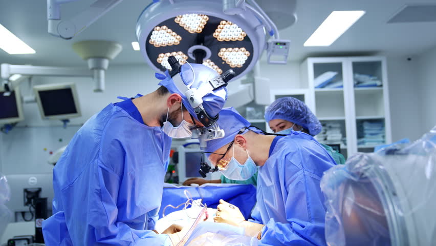 Professional neurosurgeons performing operation. Cooperating doctors in surgical loupes leaned above the patient. - Powered by Shutterstock - Get 15% off with code: PIKWIZARD15