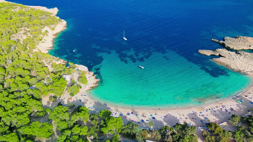Ibiza Cala Bassa beach with turquoise water, aerial drone views